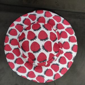 Top-down-view-of-a-white-quilted-wide-brim-sun-hat-featuring-an-artistic-jungle-pattern-with-illustrated-zebras and-green-palm-trees-placed-on-a-dark-surface.